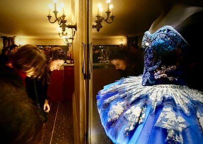 Standing beside the mirror of the blue and white flower skirt of woman
